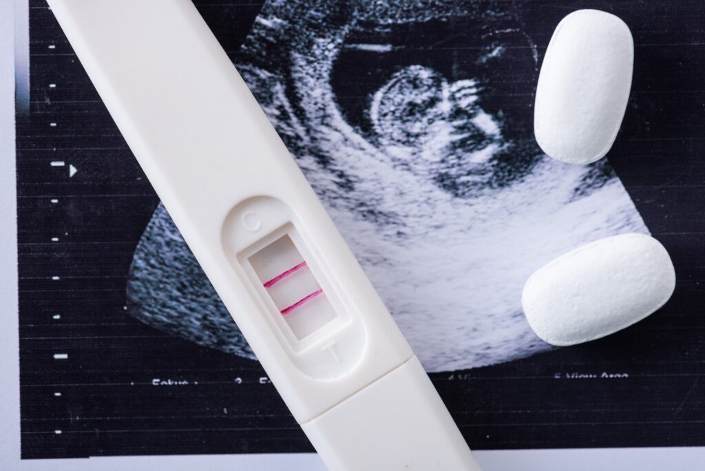 close up of pills and pregnancy test on ultrasound image